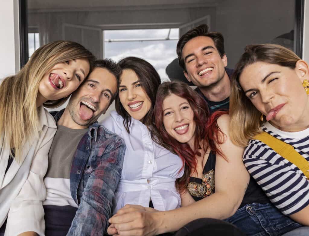 Un grupo de seis personas, entre ellas la oradora de Miami Isabel Restrepo, hacen muecas y posan muy juntos, lo que sugiere un ambiente informal y divertido.