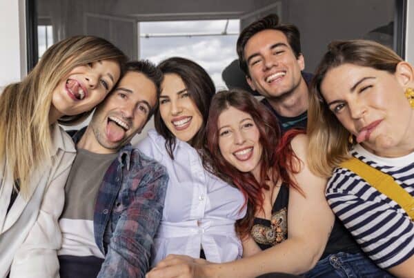 Un grupo de seis personas, entre ellas la oradora de Miami Isabel Restrepo, hacen muecas y posan muy juntos, lo que sugiere un ambiente informal y divertido.