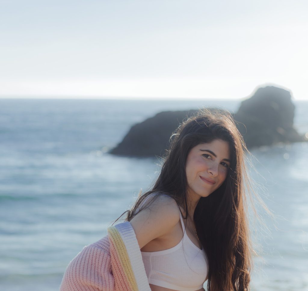 Fabiola Esber frente al mar, con mirada serena y vestida en tonos suaves, reflejando paz y creatividad femenina